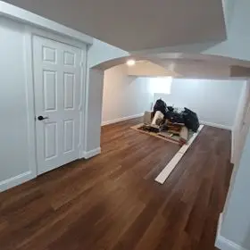 Full basement renovation with new flooring installation and finished walls by DLS Construction LLC